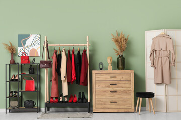 Wall Mural - Stylish interior of modern dressing room with female clothes, shoes and pampas grass