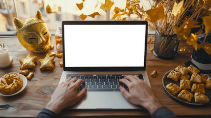 Wall Mural - Purim. Laptop mockup in the party room. A man is typing on a laptop with an empty white screen. There is a carnival golden mask and a traditional Jewish treat on a wooden table