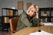 © Pixel-Shot - Worried mature businesswoman at table in office