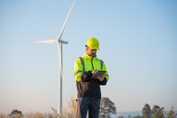 Wall Mural - engineer wearing uniform inspection and survey work in wind turbine farms rotation to generate elect