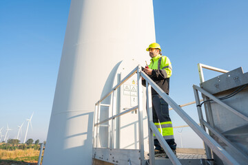 Wall Mural - engineer wearing uniform inspection and survey work in wind turbine farms rotation to generate elect