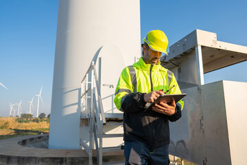 Wall Mural - engineer wearing uniform inspection and survey work in wind turbine farms rotation to generate elect