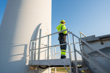 Wall Mural - engineer wearing uniform inspection and survey work in wind turbine farms rotation to generate elect