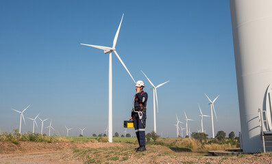 Wall Mural - engineer wearing uniform inspection and survey work in wind turbine farms rotation to generate elect