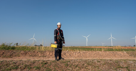 Wall Mural - engineer wearing uniform inspection and survey work in wind turbine farms rotation to generate elect