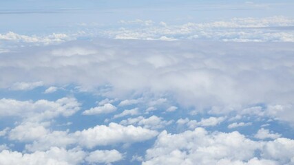 Wall Mural - view from plane over blue sky with white Fluffy clouds while flying through in sunny summer time