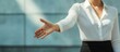 © The 2R Artificiality - Businesswoman in white blouse extending hand for handshake against light blue background with ample copyspace for text and professional composition.