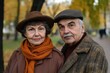 © The 2R Artificiality - Happy senior couple in stylish autumn attire standing closely in vibrant yellow park, centered composition with soft-focus trees, perfect for text overlay.