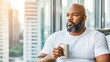 © mashimara - Morning Reflection: A contemplative man with a beard enjoys a cup of coffee while gazing out a window at a cityscape.