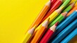© napak - A vibrant collection of colored pencils arranged against a bright yellow backdrop, showcasing a spectrum of hues and sharpened points, ready for creative expression and artistic endeavors.