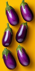 Wall Mural - Bunch of purple eggplants are lined up on a yellow background. The eggplants are arranged in a row, with each one slightly overlapping the one next to it