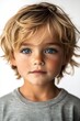 © Olly Photography - Close-up of a young child with bright blue eyes and tousled blond hair, exuding innocence and curiosity.