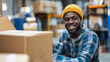 © InspirationDesign - African American warehouse worker smiling with packages. Great for logistics, workplace diversity, and professional service themes.