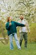 © makedonski2015 - Couples enjoy a joyful moment while walking in a blooming park during springtime.