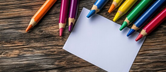 Poster - brightly colored crayons and unmarked paper on the wooden desk. with copy space image. Place for adding text or design