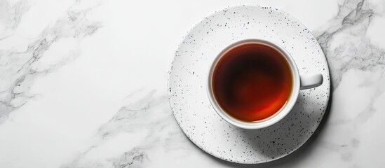 Fototapete - White cup of tea on a spotted serving plate Tea cup on a white marble surface Top view with copy space
