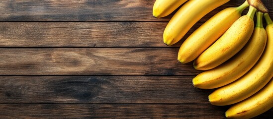 Poster - Yellow ripe bananas are arranged as a border for text on a wooden textured background top view. with copy space image. Place for adding text or design