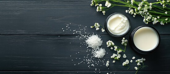 Poster - Cosmetic cream soap and bath salts featuring yarrow herbal flowers on a black wooden table. with copy space image. Place for adding text or design
