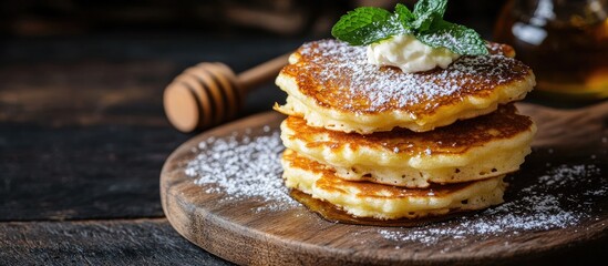 Poster - Cottage cheese pancakes topped with fresh mint and dusted with powdered sugar Syrniki served on dark wooden boards Nutritious breakfast option Cottage cheese pancakes accompanied by honey on a wood