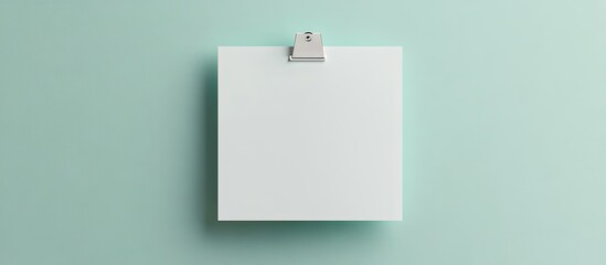 Poster - Blank light green note with a white paper clamp on a grey background viewed from above Space for text. with copy space image. Place for adding text or design