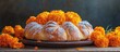 © vxnaghiyev - Pan de muerto a traditional pastry bread or bun topped with sugar and orange baked for Mexico s Day of the Dead Marigold flowers a symbol of death on a wooden background Copy space