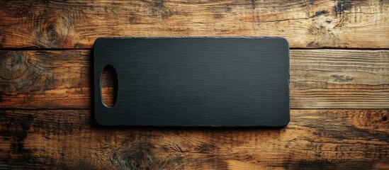 Poster - Close up of an empty black kitchen board on a wooden background. with copy space image. Place for adding text or design