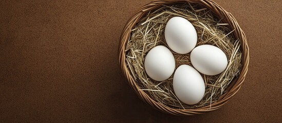 Aufkleber - White chicken eggs are placed in a wicker basket with straw atop a cork background Easter card Flat lay Copyspace