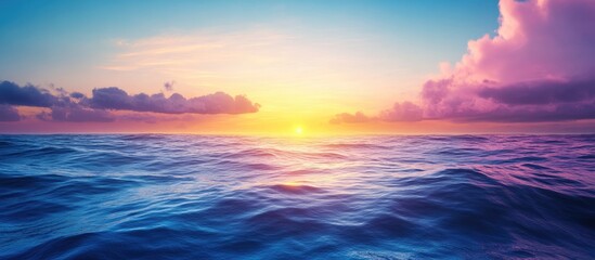Poster - Vivid colors of dawn with the sunrise above the ocean The horizon features a sky with clouds and waves A natural background showcasing a gradient of blue and pink Copy space No people present Sunli