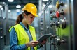 © miss irine - Female engineer inspects water quality in food production plant. Uses tablet pc to control equipment in factory. Food production facility shows modern tech. Engineer wears protective equipment.