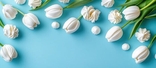 Poster - White tulips and meringue cookies against a blue background Copy space Top view