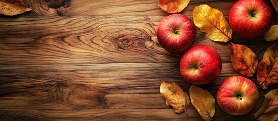 Leinwandbilder - Autumn apples with leaves on a wooden board top view. with copy space image. Place for adding text or design