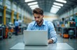 © miss irine - Man works on laptop inside factory. Businessman uses laptop for work in industrial hall. Focused on computer. Modern tech integrated into production. Employee interacts with tech. Man mature