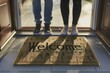 © Viktoriia - Welcome mat with two people standing at open doorway in warm light