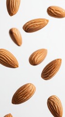 Aufkleber - Many almonds falling against a white background creating a dynamic pattern, ideal for representing concepts related to healthy food, vegan snacks, and the food industry
