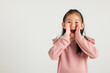 © sorapop - Asian happy portrait cute young kid girl standing hand on mouth talking news announcement studio shot isolated on white background, Thai kindergarten child announcement