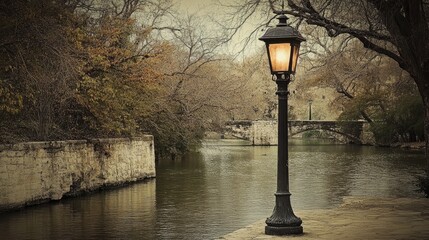 Poster - Vintage lamppost illuminating Riverwalk surrounded by serene trees and calm water reflecting autumn hues and historic architecture
