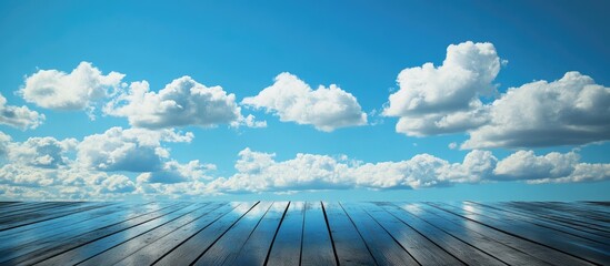 Poster - Wooden floor reflecting vibrant blue sky and white clouds ideal for interior design concepts and creative inspiration