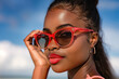 © Rezeda - A woman wearing a red pair of sunglasses is posing for a photo