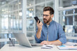 © Liubomir - Angry and furious man shouting into phone, office worker working at workplace inside office, frustrated and dissatisfied with colleagues.