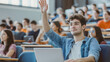 © Ariba - A Hispanic student with a laptop raises his hand during a university lecture to ask the professor a question, surrounded by a diverse group of bright, modern classmates.
