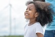 © BESTIMAGE - Young girl with curly hair is smiling and looking up at the sky