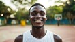 © Johannes - Happy African man smiling at camera inside basketball court - Focus on face
