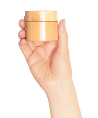 Wall Mural - Woman hand holds a wooden cosmetic cream jar, on transparent background close-up, template for cosmetics ads