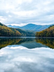 Aufkleber - Serene Mountain Lake Scene with Autumn Forest Reflections Under Cloudy Sky : Generative AI