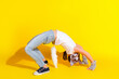 © deagreez - Young girl in casual wear performing quadrobica-inspired pose with a cat-themed mask on vibrant yellow background