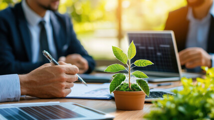 Aufkleber - business meeting focused on green economy, featuring small plant in pot, laptops, and professionals discussing sustainability. atmosphere is collaborative and forward thinking