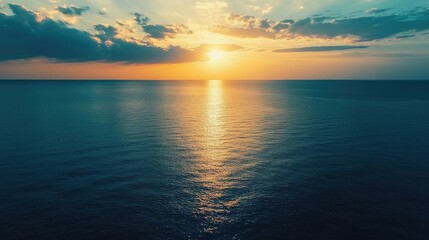 Poster - Aerial view of tranquil ocean water reflecting sunset colors with soft clouds and ample space for adding text or graphics