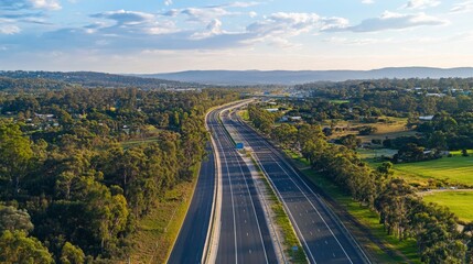 Poster - A modern motorway stretching into the horizon, surrounded by lush green landscapes and a bright blue sky.