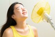 © nsit0108 - Happy woman enjoying cool air flow from electric fan, refreshing during summer heat