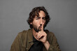 © kues1 - looking serious and cross with finger pressed to lips demanding silence or quiet, keeping a secret